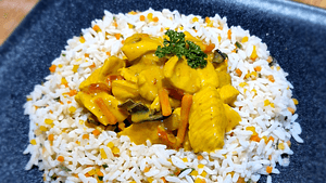Émincé de poulet suisse à la sauce curry coco 250 g, servi avec riz aux petits légumes 200 g.
